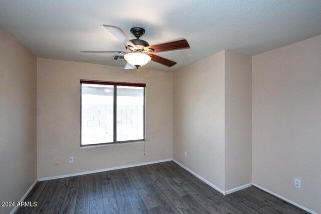 empty room featuring ceiling fan and dark wood-type flooring