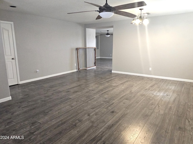 unfurnished room with ceiling fan with notable chandelier and dark hardwood / wood-style floors