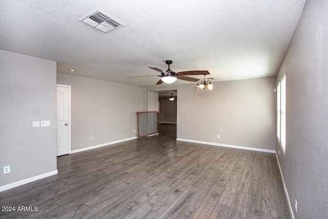 empty room with a textured ceiling, dark hardwood / wood-style floors, and ceiling fan