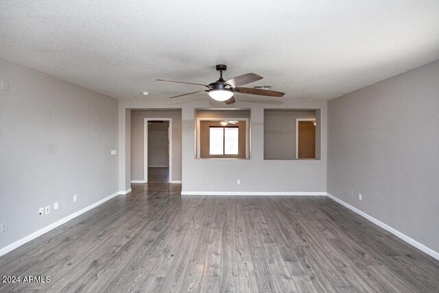 spare room with ceiling fan, a textured ceiling, and dark wood-type flooring