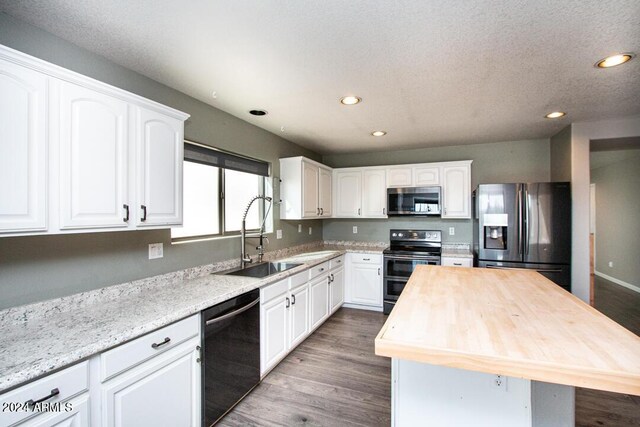 kitchen featuring black appliances, white cabinetry, and sink