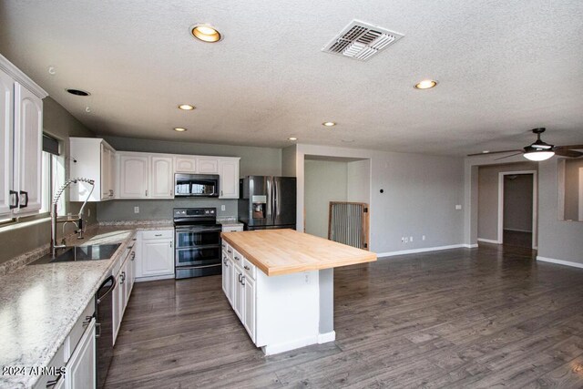 kitchen with white cabinets, stainless steel appliances, dark wood-type flooring, and a center island