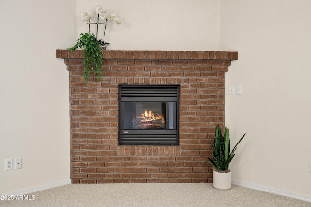 room details with baseboards, carpet, and a brick fireplace