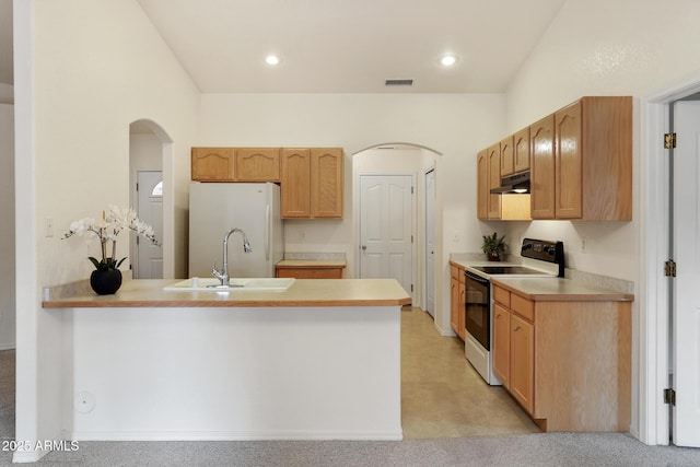 kitchen featuring white appliances, arched walkways, under cabinet range hood, and a sink