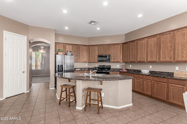2945 E Clifton Ave, Gilbert, AZ 85295 - kitchen featuring stainless steel appliances, arched walkways, brown cabinets, a sink, and light tile patterned floors
