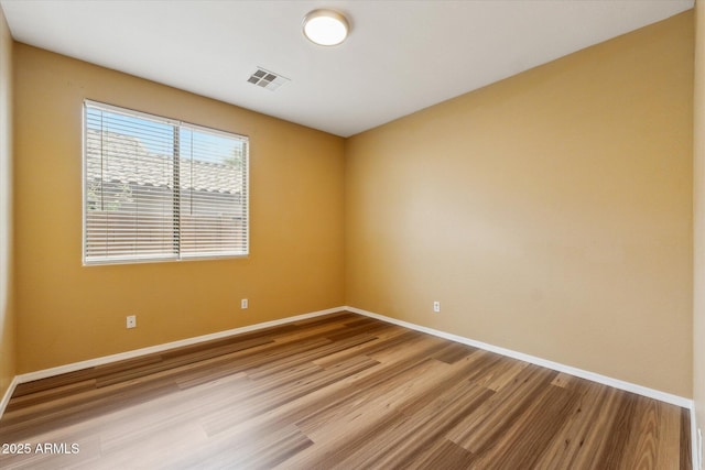 unfurnished room featuring wood finished floors and baseboards