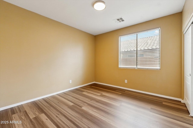 unfurnished room with light wood finished floors and baseboards
