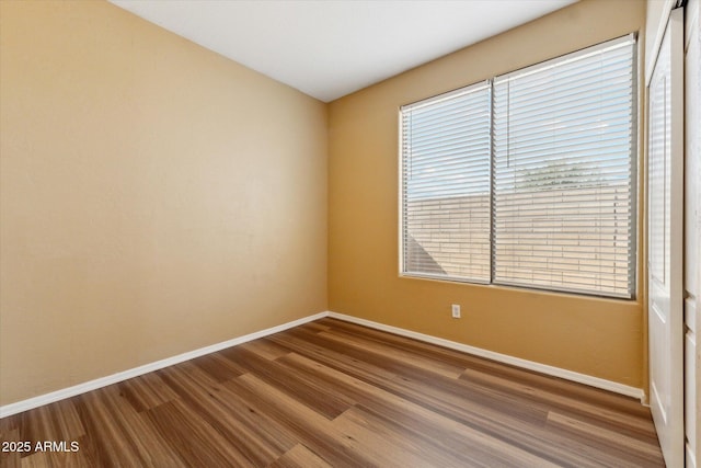empty room featuring baseboards and wood finished floors