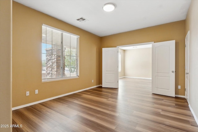unfurnished bedroom with wood finished floors and baseboards