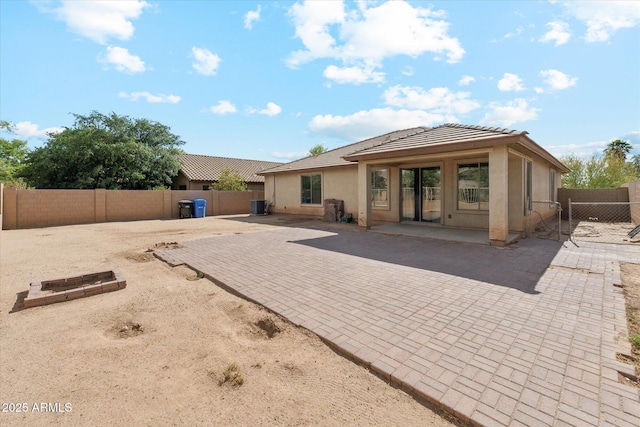 back of house with stucco siding, a patio, a fenced backyard, and a tile roof