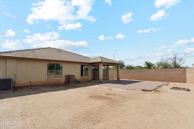 rear view of house featuring a fenced backyard, a patio, cooling unit, a tile roof, and stucco siding