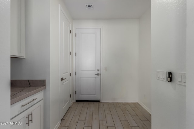 clothes washing area with light hardwood / wood-style floors