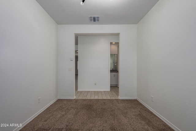 unfurnished room featuring light carpet