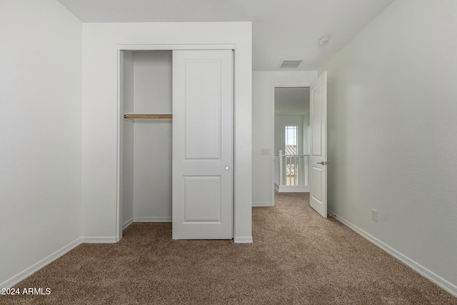 unfurnished bedroom with a closet and carpet floors