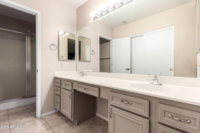 bathroom featuring a sink, visible vents, double vanity, and tile patterned floors