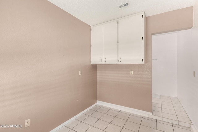 laundry area featuring light tile patterned flooring, visible vents, and baseboards