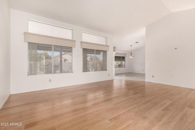 unfurnished living room featuring lofted ceiling and light wood-type flooring