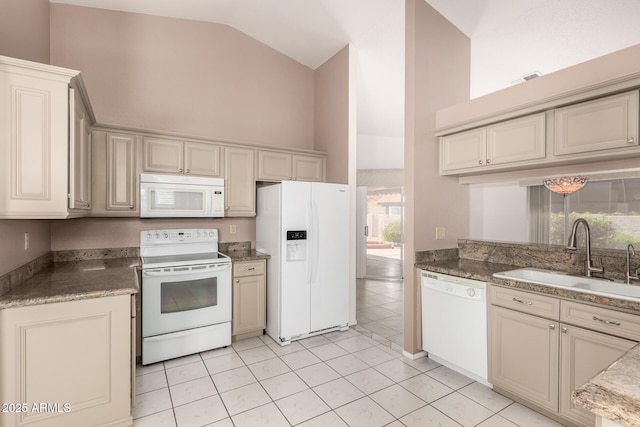 kitchen with white appliances, light stone counters, visible vents, high vaulted ceiling, and a sink