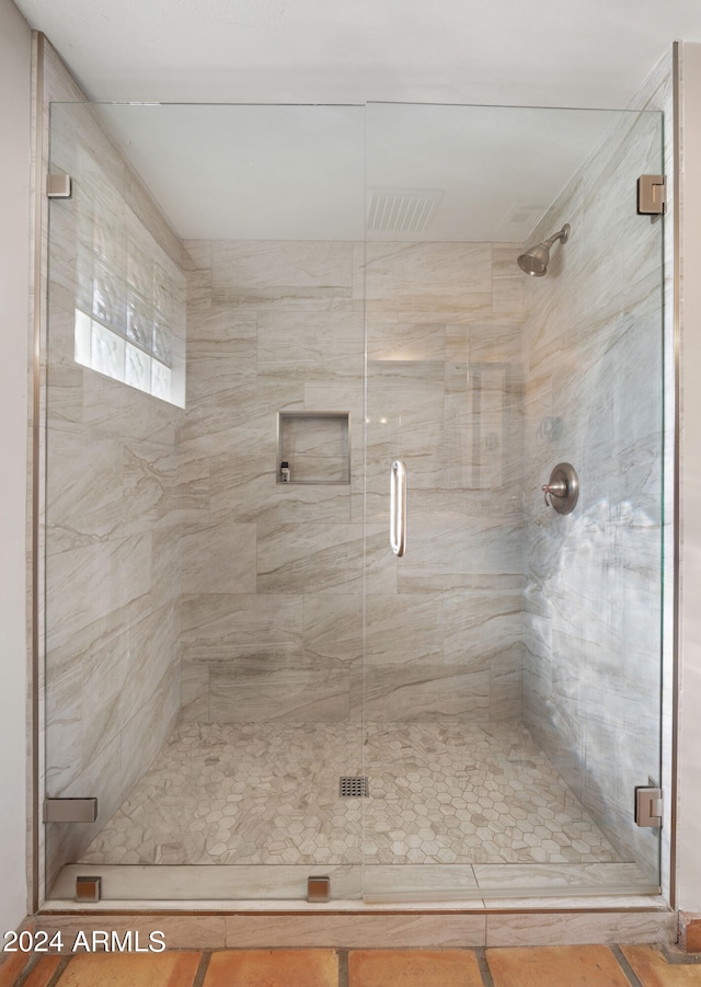 bathroom featuring a shower with door