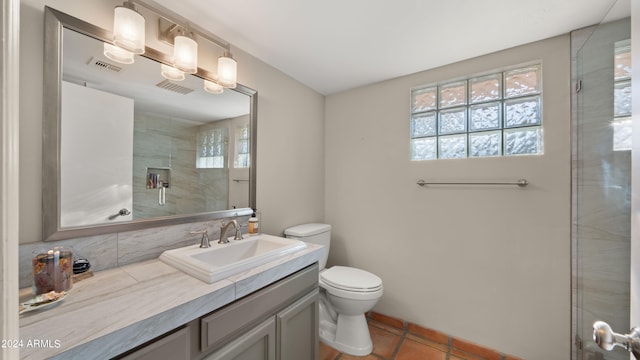 bathroom featuring tile patterned flooring, a shower with door, vanity, and toilet