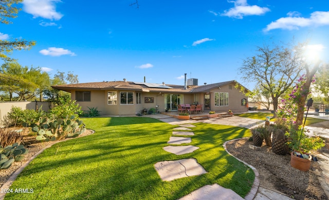 rear view of house featuring a patio area and a yard