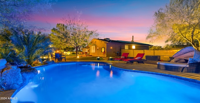 pool at dusk featuring a patio area