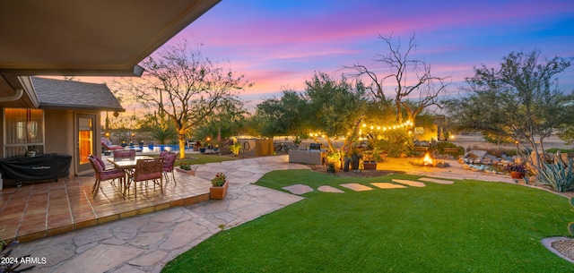 yard at dusk featuring a patio area