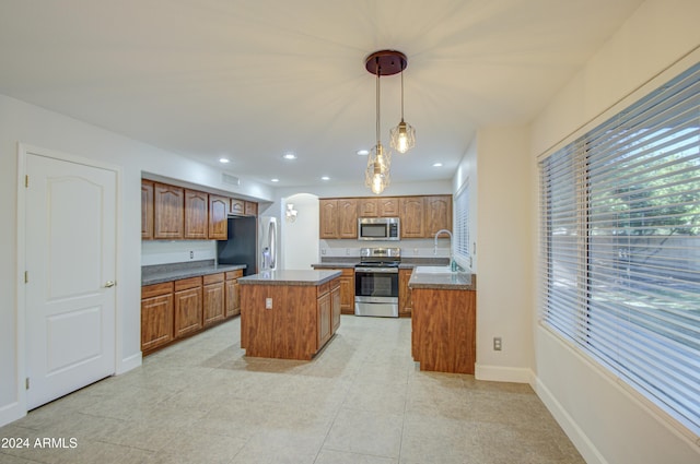 kitchen featuring appliances with stainless steel finishes, a center island, decorative light fixtures, sink, and light tile patterned floors