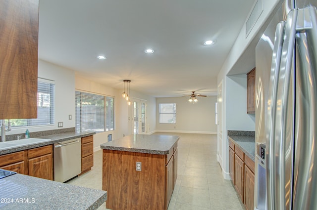 kitchen featuring ceiling fan, pendant lighting, a center island, sink, and stainless steel appliances