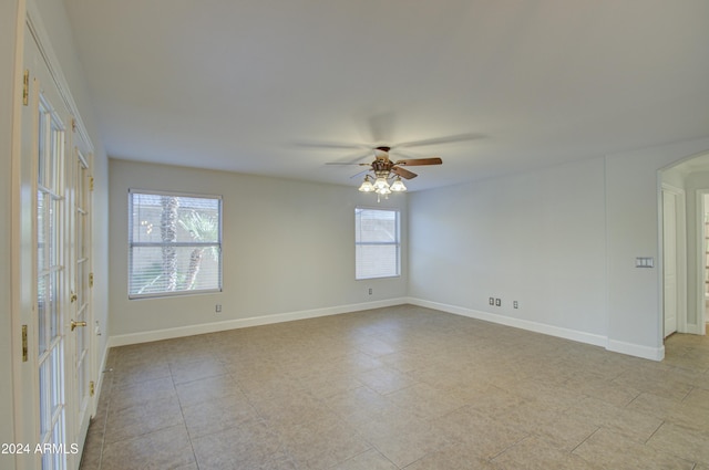 spare room featuring ceiling fan and plenty of natural light