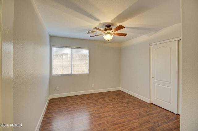 unfurnished room featuring ceiling fan and dark wood-type flooring