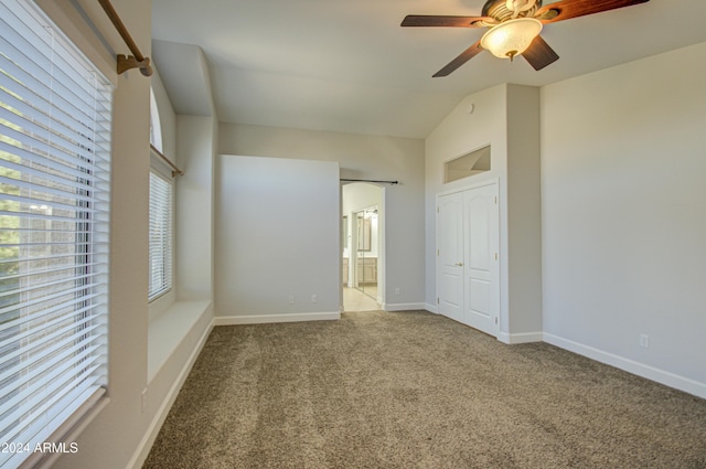 unfurnished bedroom featuring vaulted ceiling, ceiling fan, ensuite bathroom, and carpet