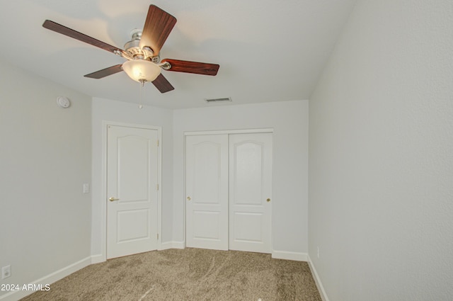 unfurnished bedroom featuring ceiling fan, a closet, and carpet floors