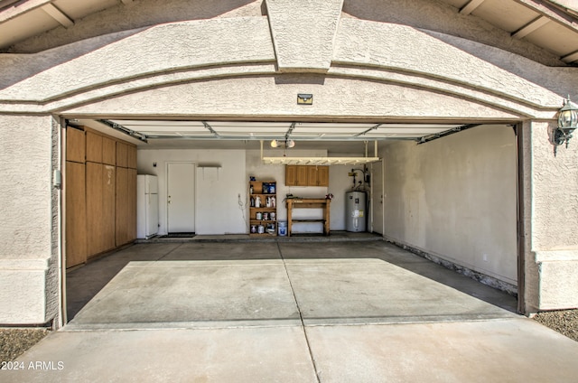 garage featuring water heater, a garage door opener, and white refrigerator