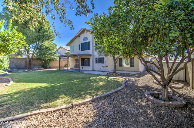 back of house with a patio area and a yard