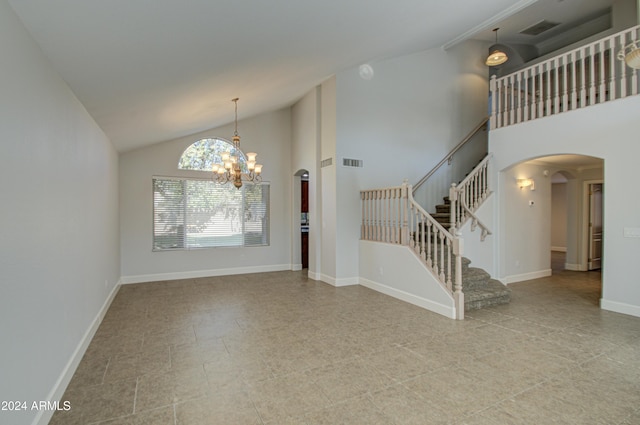 unfurnished room with high vaulted ceiling and an inviting chandelier