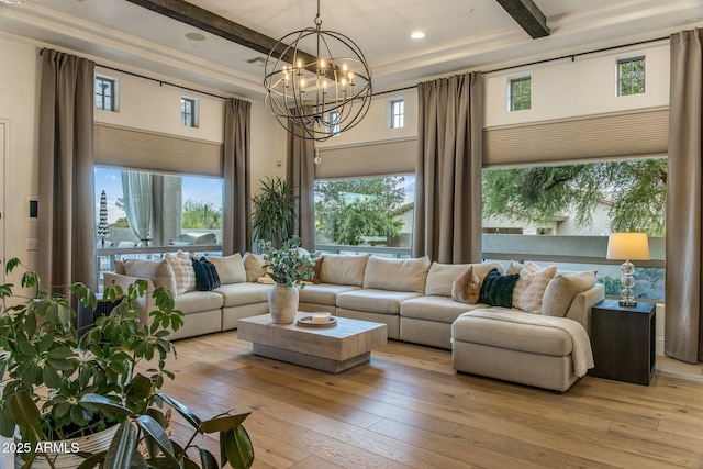living room with beamed ceiling, recessed lighting, light wood-style flooring, and a chandelier