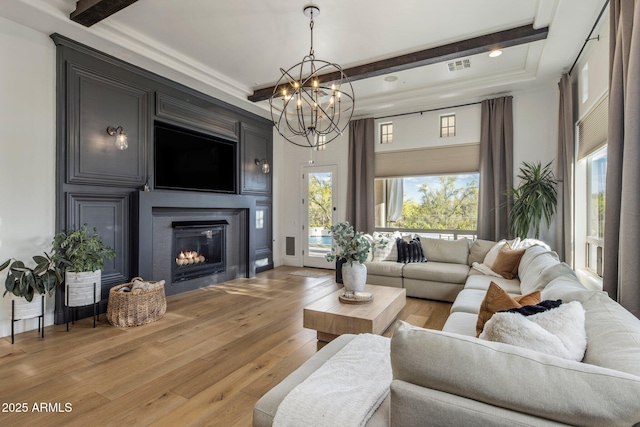 living area featuring light wood-style flooring, a notable chandelier, beam ceiling, and visible vents