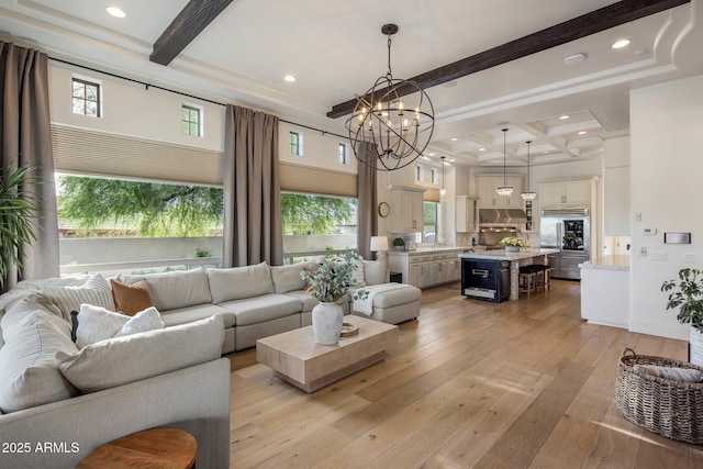 living room with an inviting chandelier, light wood-style flooring, coffered ceiling, and beam ceiling