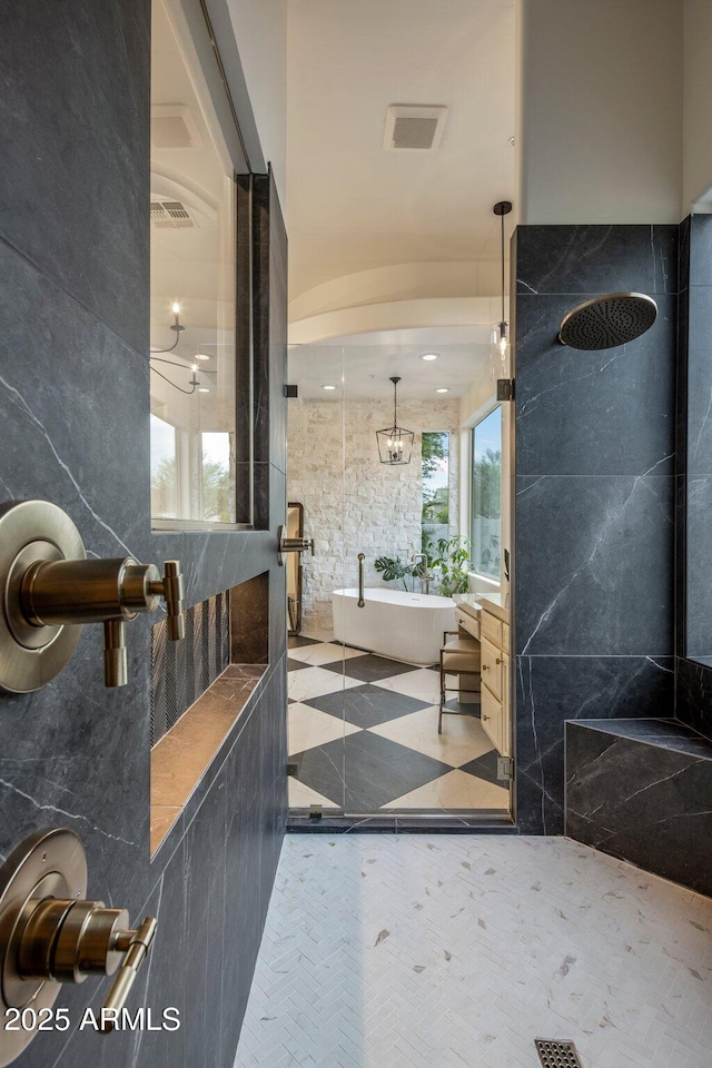 bathroom featuring a freestanding tub, visible vents, and a tile shower