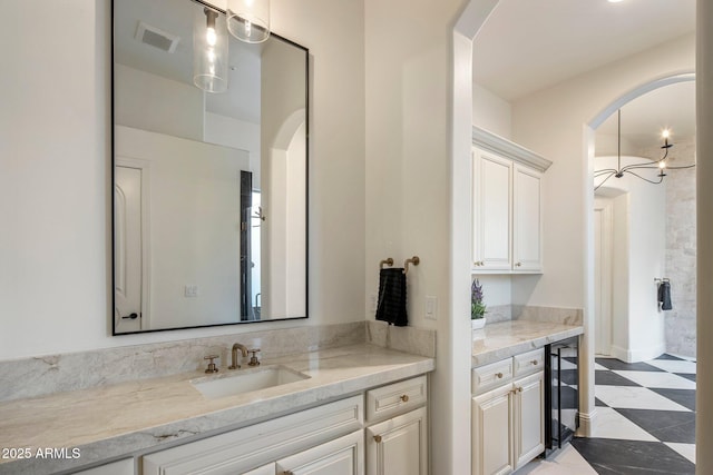 full bath with vanity, visible vents, and beverage cooler
