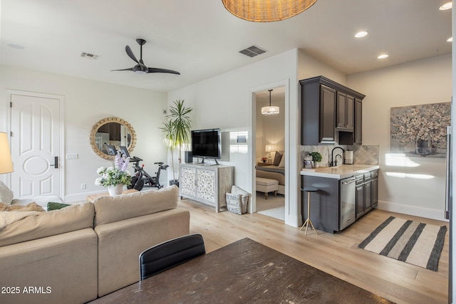 living room with recessed lighting, a ceiling fan, light wood finished floors, and visible vents