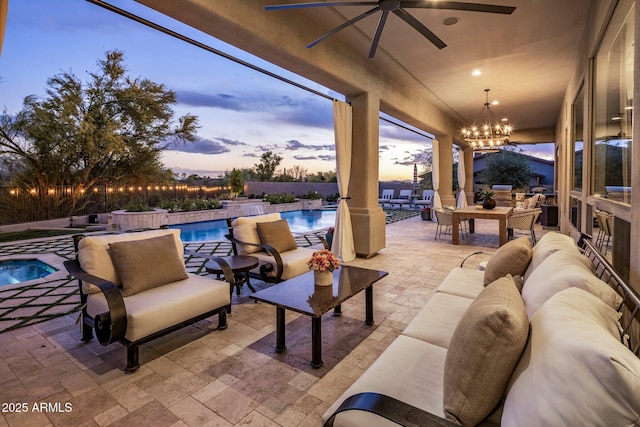 patio terrace at dusk with a ceiling fan, an outdoor hangout area, and an outdoor pool