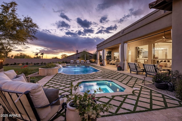 pool at dusk featuring an outdoor living space, an in ground hot tub, a fenced in pool, and a patio