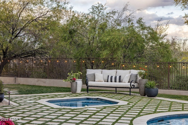 view of swimming pool featuring a patio, outdoor lounge area, fence, and an in ground hot tub
