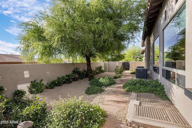view of yard with a fenced backyard and central AC