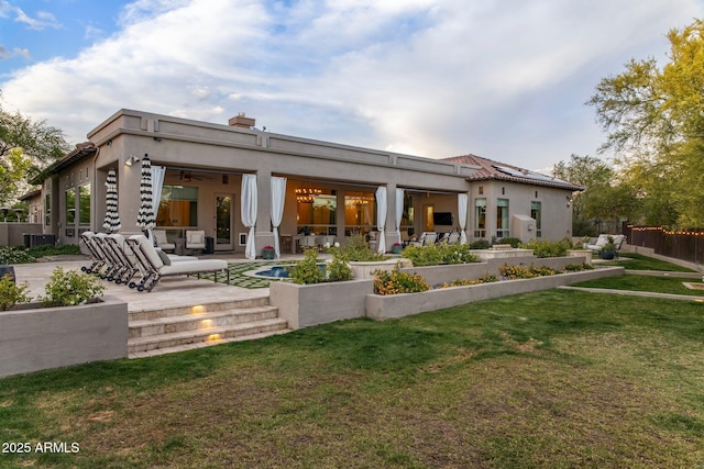 back of house featuring fence, a ceiling fan, a yard, and a patio area