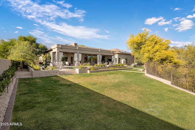 rear view of property with a fenced backyard, a patio, ceiling fan, and a yard