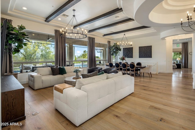 living area featuring plenty of natural light, visible vents, beamed ceiling, a notable chandelier, and light wood-style floors