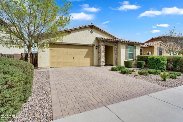 view of front of property with fence, a tile roof, stucco siding, decorative driveway, and an attached garage